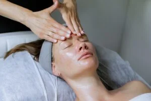 aesthetician applying serum to a relaxed woman's face in a medical spa